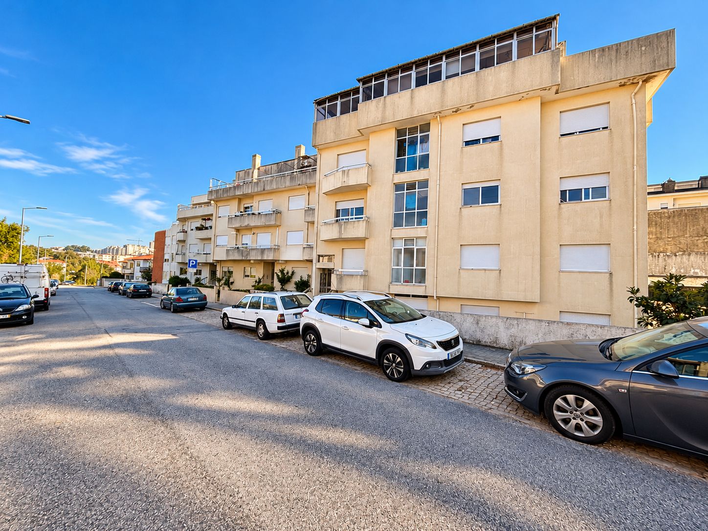 Rua Residencial ao Sol com Carros Estacionados